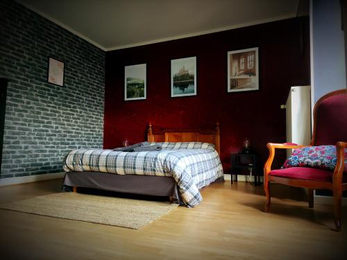 um quarto com uma cama e uma parede de tijolos em La cachette sous l'escalier, le gîte ensorcelé 