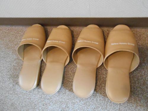 four pairs of shoes are lined up on the floor at Select Inn Mishima in Mishima