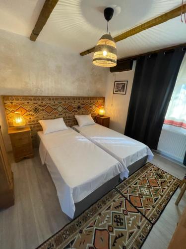 a bedroom with a large white bed and a rug at Hotel Casa Romaneasca in Otopeni
