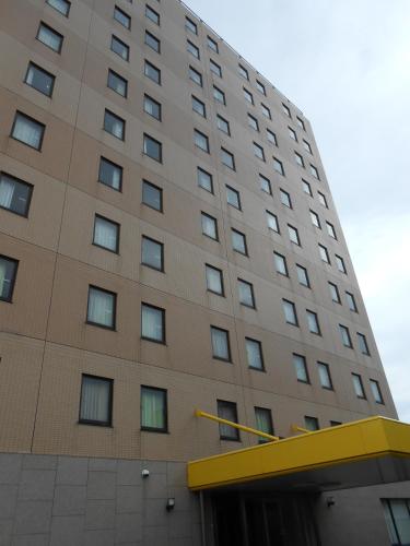 a tall brown building with a yellow roof at Select Inn Mishima in Mishima