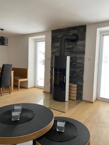 a living room with two tables and a fireplace at Chalupa Haj 109 in Loučná pod Klínovcem