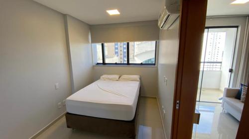 uma pequena cama em um quarto com janela em Flat Essenciale Style1602 em Goiânia