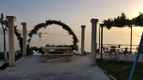 an arch with a picnic table and a table with a bench at Apartments Romario in Sarandë