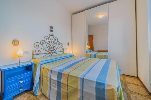 a bedroom with a bed with a blue dresser and a mirror at Trilocale Naldina a Marciana Marina in Marciana Marina