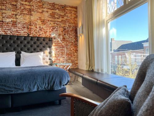 a bedroom with a bed and a large window at Van der Gang Suites uniek design in hartje Dokkum in Dokkum