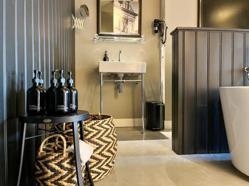 een badkamer met een wastafel en een tafel met flessen erop bij Van der Gang Suites in Dokkum
