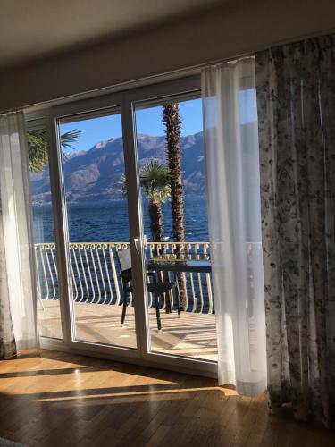 a room with a large window with a view of the ocean at Casa Conti al Lago in Ronco s/Ascona - Porto Ronco