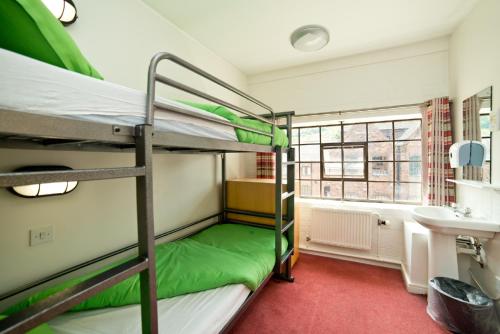 a room with two bunk beds and a bathroom at YHA Ironbridge Coalport in Coalport