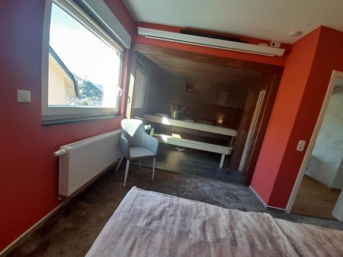 a room with a red wall with a chair and a window at Anitas Ferienhaus in Cochem