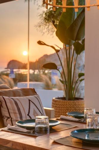 a wooden table with plates and glasses on it at Hotel Benois in Galissas