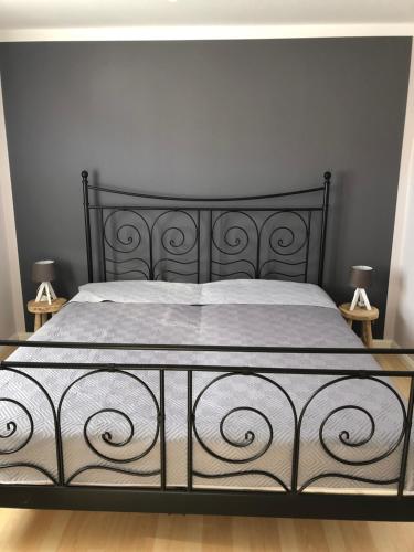 a bed with a black and white bed frame and two lamps at Lindenbaum in Hargesheim