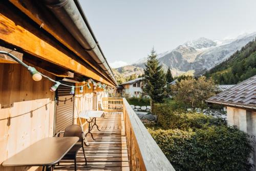 a balcony of a house with a table and chairs at Farmhouse with 4 bedrooms 4 bathrooms parking sauna terrace and garden in Chamonix