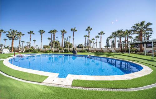 a large swimming pool with palm trees in the background at Beautiful Apartment In Orpesa Del Mar in Oropesa del Mar