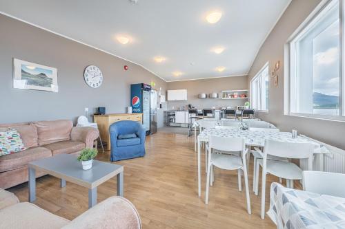 uma sala de estar com mesas e cadeiras e uma cozinha em Stöð Guesthouse and apartments em Grundarfjordur