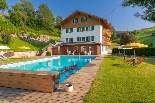 a house with a swimming pool in front of a house at Garni Hotel Melissa in Castelrotto