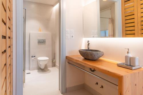 a bathroom with a sink and a toilet at Villa Yaisemi by PosarelliVillas in Kavalléraina
