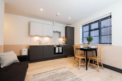 a kitchen and living room with a table and chairs at 1 Castle Mews in Salisbury
