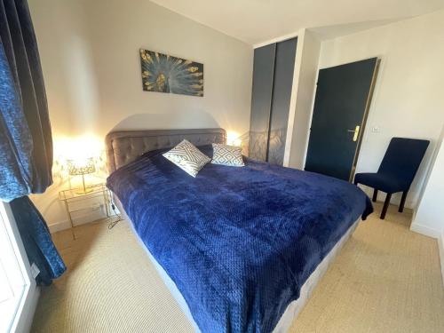 1 dormitorio con cama azul y manta azul en Blue Haven Sèvres en Sèvres