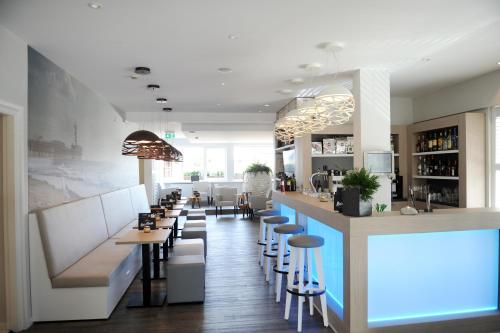 ein Restaurant mit einer Bar mit Hockern in der Unterkunft Hotel Andante aan Zee in Scheveningen