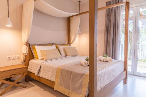 a bedroom with a canopy bed with two towels at Villa Yaisemi by PosarelliVillas in Kavalléraina