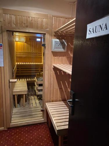 a locker room with wooden benches in a room at Hotel Miraj - Restaurant & Sauna & Biliard in Poiana Brasov