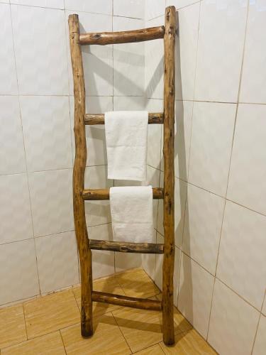 a wooden towel rack with towels on it in a bathroom at Maisara Mafia Beach Lodge in Kilindoni