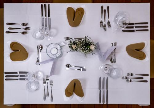 a white table with silverware and utensils on it at Hotel-Restaurant Gollner in Lebring
