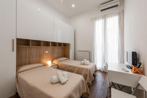 um quarto de hotel com duas camas e uma televisão em Central loft full comfort em Bari