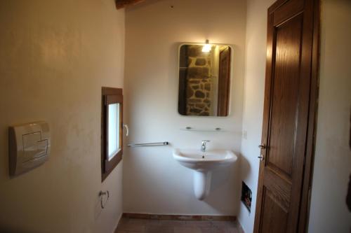 ein Bad mit einem Waschbecken und einem Wandspiegel in der Unterkunft Stazzo Gallurese La Cugara in Aglientu