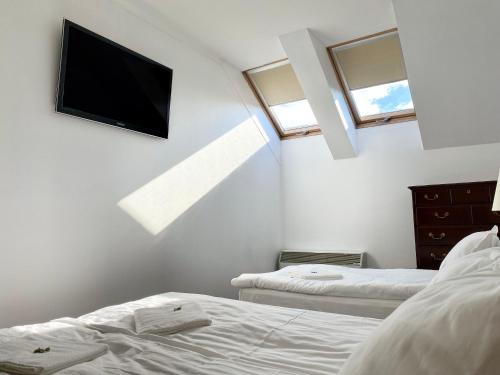 a bedroom with two beds and a flat screen tv at OPERA16 Guestrooms in Budapest