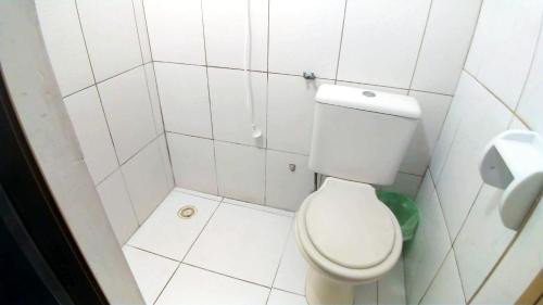 a small bathroom with a white toilet and a toilet paper dispenser at HOTEL PAULISTANO Terminal Tietê in Sao Paulo