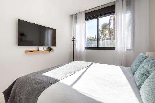 een slaapkamer met een bed, een tv en een raam bij Luxury High End - Santa Barbara Heights III CLC - Private Pool in Mijas Costa