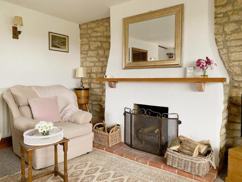 a living room with a chair and a fireplace at Grange Farm Cottage in Sleaford