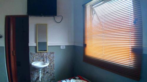a bathroom with a sink and a mirror and a window at HOTEL PAULISTANO Terminal Tietê in Sao Paulo