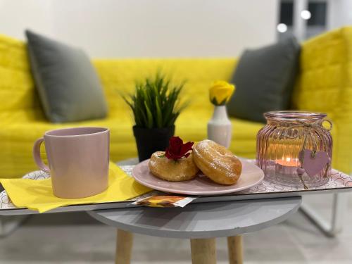 a table with a plate of donuts and a cup of coffee at Viktoria House in Odorheiu Secuiesc