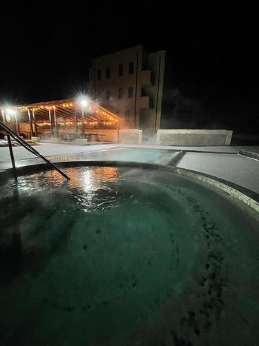 a large pool of water in front of a building at night at Pensiunea Palace in Baile Felix