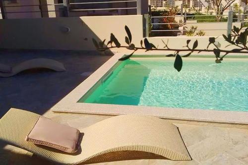 a pool with a chair and a towel next to it at Villa Etienne - Key to Villas in Valledoria