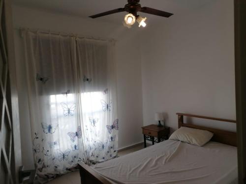 a bedroom with a bed and a ceiling fan at Fully Furnished 4-Bed Town House in Mountain View Ras Al-Hekma in Ras Elhekma