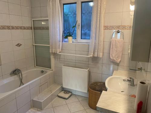ein Badezimmer mit einer Badewanne, einem Waschbecken und einem WC in der Unterkunft Suburb Hostel in Purkersdorf