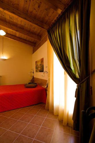 a bedroom with a red bed and a window at Olympo in Bisceglie