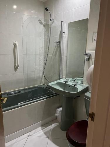 a bathroom with a sink and a shower and a toilet at Caledonian Hotel in Dumfries