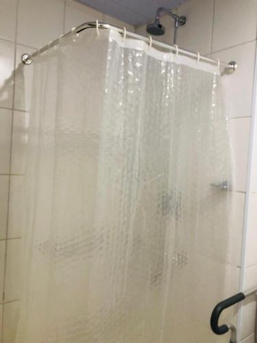 a shower with a white shower curtain in a bathroom at Hotel Golden Park Sorocaba & Convenções by Nacional Inn in Sorocaba