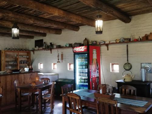 a restaurant with a coca cola machine and tables and chairs at Blood River Museum Guesthouse in Dundee