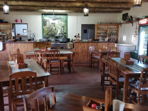 a restaurant with wooden tables and chairs and a kitchen at Blood River Museum Guesthouse in Dundee