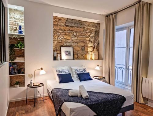 une chambre avec un grand lit avec des oreillers bleus dans l'établissement Le Capucin - Balnéo - Lyon Centre - Majord'Home, à Lyon