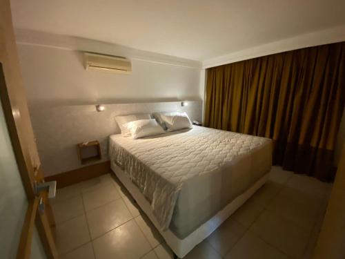 a bedroom with a white bed in a room at Varandas - Apartamentos in Natal