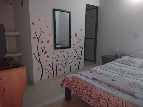 a bedroom with a bed and a mirror on the wall at Casa Pacha in Guaduas