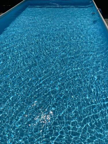 a pool of blue water in a swimming pool at Viktoria House in Odorheiu Secuiesc