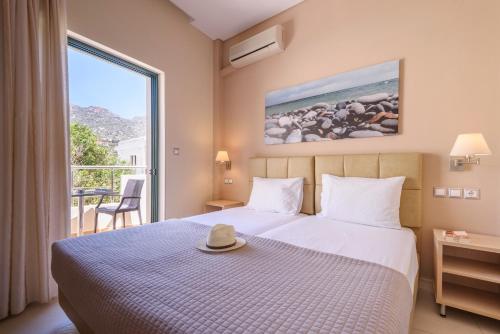 una habitación de hotel con una cama con sombrero en Poseidon Studios, en Palaiochóra