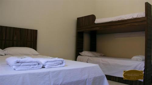 two bunk beds with towels on top of them at Chalé Recanto Monte Sinai in Piracaia